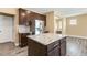 Open kitchen features stainless steel appliances, granite countertops, and dark wood cabinets at 141 Beldenshire Way, Holly Springs, NC 27540
