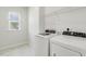 Bright laundry room with washer, dryer, shelf, and tiled floors at 141 Beldenshire Way, Holly Springs, NC 27540