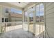 Screened-in porch with concrete flooring, white railings, and a glass door to the backyard at 141 Beldenshire Way, Holly Springs, NC 27540