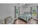 Bright bedroom with windows, a metal bed frame, wood floors, and neutral tones at 141 S Broad E St, Angier, NC 27501