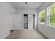 A bedroom with carpet, trim work and window showing a view of the lush green trees at 1413 Glenwater Dr, Cary, NC 27519