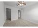 A neutral-colored bedroom includes a ceiling fan, carpeted flooring, and access to the closet at 1413 Glenwater Dr, Cary, NC 27519