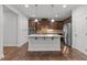Modern kitchen with dark wood cabinets, stainless steel appliances, and a center island with quartz countertops at 1413 Glenwater Dr, Cary, NC 27519
