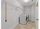 Well-lit laundry room with tile floors and white appliances at 1413 Glenwater Dr, Cary, NC 27519