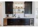 Bar area featuring dark cabinets, light countertops, display shelves, and beverage refrigerators at 15 Magnolia Ln, Youngsville, NC 27596