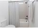 Cozy bathroom featuring a shower-tub combo with a modern shower curtain and neutral tile at 15 Magnolia Ln, Youngsville, NC 27596