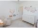 Bright Bedroom with a cozy armchair, crib, stylish decor, and a door to a hallway at 15 Magnolia Ln, Youngsville, NC 27596