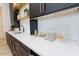 Close-up of white countertop with black cabinetry, brass hardware, open shelving, and decorative barware at 15 Magnolia Ln, Youngsville, NC 27596