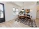 Dining room with modern lighting, six chairs, sideboard, wood floors, and large black frame windows at 15 Magnolia Ln, Youngsville, NC 27596