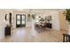 Open-concept dining room featuring modern lighting, six chairs, black doors, and hardwood floors at 15 Magnolia Ln, Youngsville, NC 27596