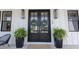 Elegant double front doors adorned with wreaths, flanked by potted plants at 15 Magnolia Ln, Youngsville, NC 27596