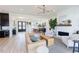 Open-concept living room featuring a modern light fixture, tan sofa, fireplace, and open dining area at 15 Magnolia Ln, Youngsville, NC 27596