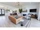 Open-concept living room with a modern sofa, fireplace, and open access to dining and entry areas at 15 Magnolia Ln, Youngsville, NC 27596