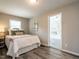 Cozy bedroom with a comfortable bed, wood-look floors, neutral walls, and a bright sunroom beyond at 1612 Bethlehem Rd, Knightdale, NC 27545