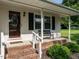 Inviting front porch with a seating bench, brick stairs, and a decorative front door at 1612 Bethlehem Rd, Knightdale, NC 27545