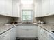 Bright kitchen featuring granite countertops, sleek white cabinets, and stainless steel appliances at 1612 Bethlehem Rd, Knightdale, NC 27545