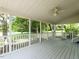 Screened-in porch with white railings and a ceiling fan overlooking the lush green yard at 1612 Bethlehem Rd, Knightdale, NC 27545
