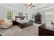 Spacious bedroom featuring tray ceilings, neutral carpet, and a cozy chair at 1612 Old Bramble Ln, Fuquay Varina, NC 27526