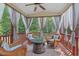 Relaxing screened-in porch featuring a stone fire pit and comfortable wicker furniture at 1612 Old Bramble Ln, Fuquay Varina, NC 27526