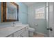 Well-lit bathroom featuring a decorative mirror, single sink vanity, and window at 191 Bridle Dr, Angier, NC 27501