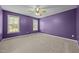Spacious bedroom with plush carpet, ceiling fan, and natural light from two windows at 191 Bridle Dr, Angier, NC 27501