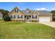 Charming home featuring blue shutters, a well-manicured lawn, and an attached garage at 191 Bridle Dr, Angier, NC 27501