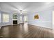 Bright living room featuring hardwood floors, a fireplace, a ceiling fan, and access to other rooms at 191 Bridle Dr, Angier, NC 27501