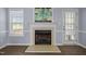 Close-up of the fireplace featuring a white mantle, a gas insert, a painting, and a large window at 191 Bridle Dr, Angier, NC 27501