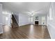 Open-concept living room featuring hardwood floors, gray walls, a fireplace and a staircase to the second floor at 191 Bridle Dr, Angier, NC 27501