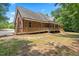 Rear view of home featuring a wooden deck and ramp, surrounded by mature trees at 2015 Saddlebrook Dr, Archer Lodge, NC 27527