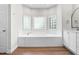 Bathroom features a large soaking tub with tiled surround, glass block window, and double vanity at 2015 Saddlebrook Dr, Archer Lodge, NC 27527