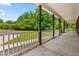 Spacious covered porch with white railings and dark columns overlooking a lush green lawn at 2015 Saddlebrook Dr, Archer Lodge, NC 27527