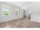 Bright, spacious living room with wood-look floors, white wainscoting, and a view of the front entry at 2015 Saddlebrook Dr, Archer Lodge, NC 27527