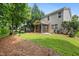 Spacious backyard features a screened porch, lush greenery, and mature trees at 2018 Remington Oaks Cir, Cary, NC 27519