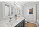 Bathroom with dual sinks, modern fixtures, and wood-look floors at 2018 Remington Oaks Cir, Cary, NC 27519