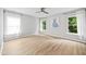 Spacious bedroom with wood-look floors, ceiling fan, and plenty of natural light at 2018 Remington Oaks Cir, Cary, NC 27519