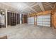 Spacious garage features concrete flooring, shelving, and multiple overhead doors at 2018 Remington Oaks Cir, Cary, NC 27519