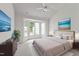 Bright primary bedroom featuring large windows, a ceiling fan, and a comfortable king-size bed at 206 Lake Brandt Dr, Cary, NC 27519