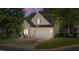 Charming home featuring neutral siding, a two-car garage, and well-maintained landscaping at dusk at 206 Lake Brandt Dr, Cary, NC 27519