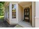 Inviting front porch with a decorative wreath, a full glass storm door, and a window overlooking landscaping at 206 Lake Brandt Dr, Cary, NC 27519