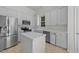 A bright kitchen featuring white cabinets, stainless appliances, and an island at 206 Lake Brandt Dr, Cary, NC 27519