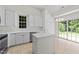 Bright kitchen featuring white cabinets, island, and tile flooring at 206 Lake Brandt Dr, Cary, NC 27519