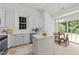 Well-lit kitchen with white cabinets, island, and a view to the backyard at 206 Lake Brandt Dr, Cary, NC 27519