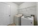 Well-lit laundry room with washer, dryer, storage shelf, and a door to a adjacent room at 206 Lake Brandt Dr, Cary, NC 27519