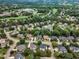Aerial view of a residential neighborhood with mature trees, well-maintained homes, and a nearby golf course at 2224 Narrawood St, Raleigh, NC 27614