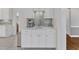 Wet bar area with white marble countertops, mosaic backsplash, stainless steel sink, and cabinetry at 2224 Narrawood St, Raleigh, NC 27614