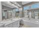 Spacious bathroom with white double vanities, a large mirror, and a soaking tub at 2224 Narrawood St, Raleigh, NC 27614