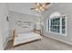 Bright bedroom features a ceiling fan, carpeted floors, and a large window with natural light at 2224 Narrawood St, Raleigh, NC 27614