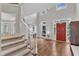 Grand foyer featuring hardwood floors, a staircase, and a bright red front door at 2224 Narrawood St, Raleigh, NC 27614