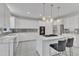 Modern kitchen features white cabinets, marble countertops, stainless appliances and an island with seating at 2224 Narrawood St, Raleigh, NC 27614